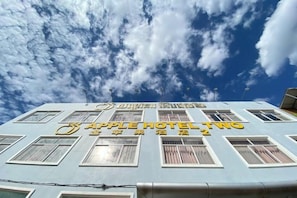 Un edificio de hotel con cielo despejado y nubes.