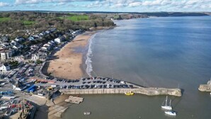 An aerial view of a coastal town with a sandy beach, a marina, and residential buildings. - Footsteps - 2 Bedroom Apartment - Saundersfoot (Saundersfoot)