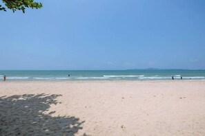 A beach with a clear sky, calm sea, and a few people in the distance. - Majestic Residence Pool 51, Pratumnak, Pattaya (Pattaya)