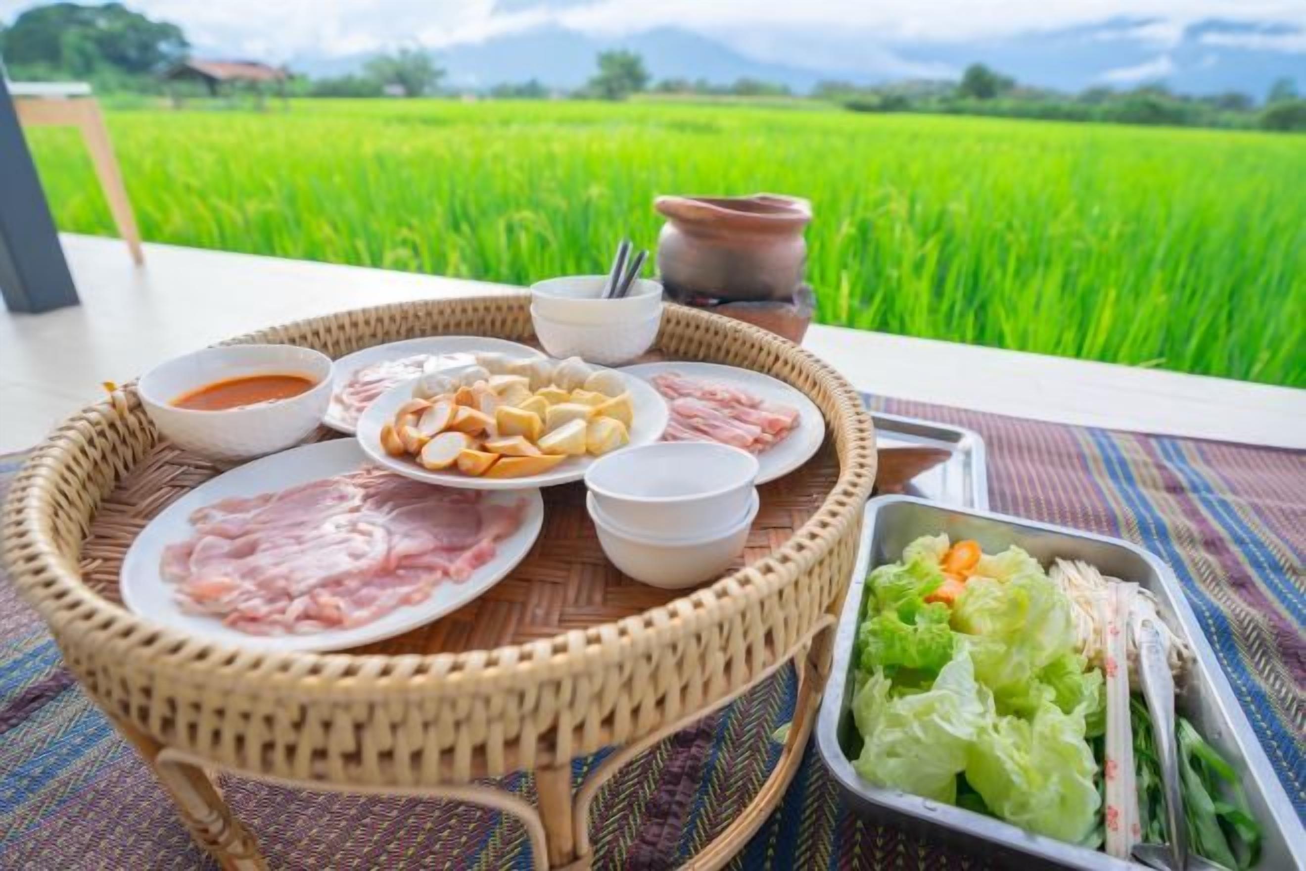 A dining setup with a variety of dishes and a view of a green field.