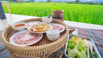 A dining setup with a variety of dishes and a view of a green field.