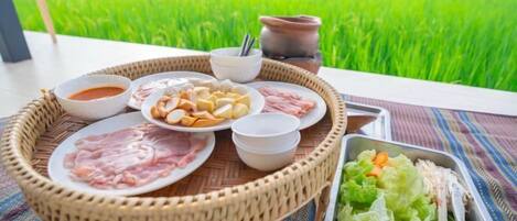 A dining setup with a variety of dishes and a view of a green field.