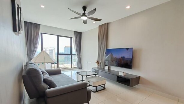 A modern living room with a sofa, coffee table, TV, and a ceiling fan. - Southkey Mosaic @ sweethome (Johor Bahru)