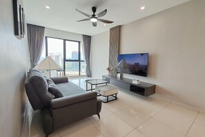 Een moderne woonkamer met een bank, salontafel, televisie en plafondventilator.
