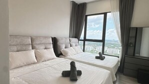 A hotel room with two beds, a large window with a city view, and a television on a stand. - Southkey Mosaic @ sweethome (Johor Bahru)