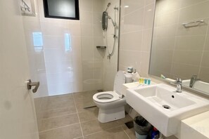 Une salle de bain moderne équipée de toilettes, d’un lavabo et d’une douche.
