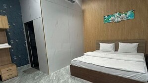 Une chambre à coucher avec un lit, une tête de lit en bois et une œuvre d’art accrochée au mur.