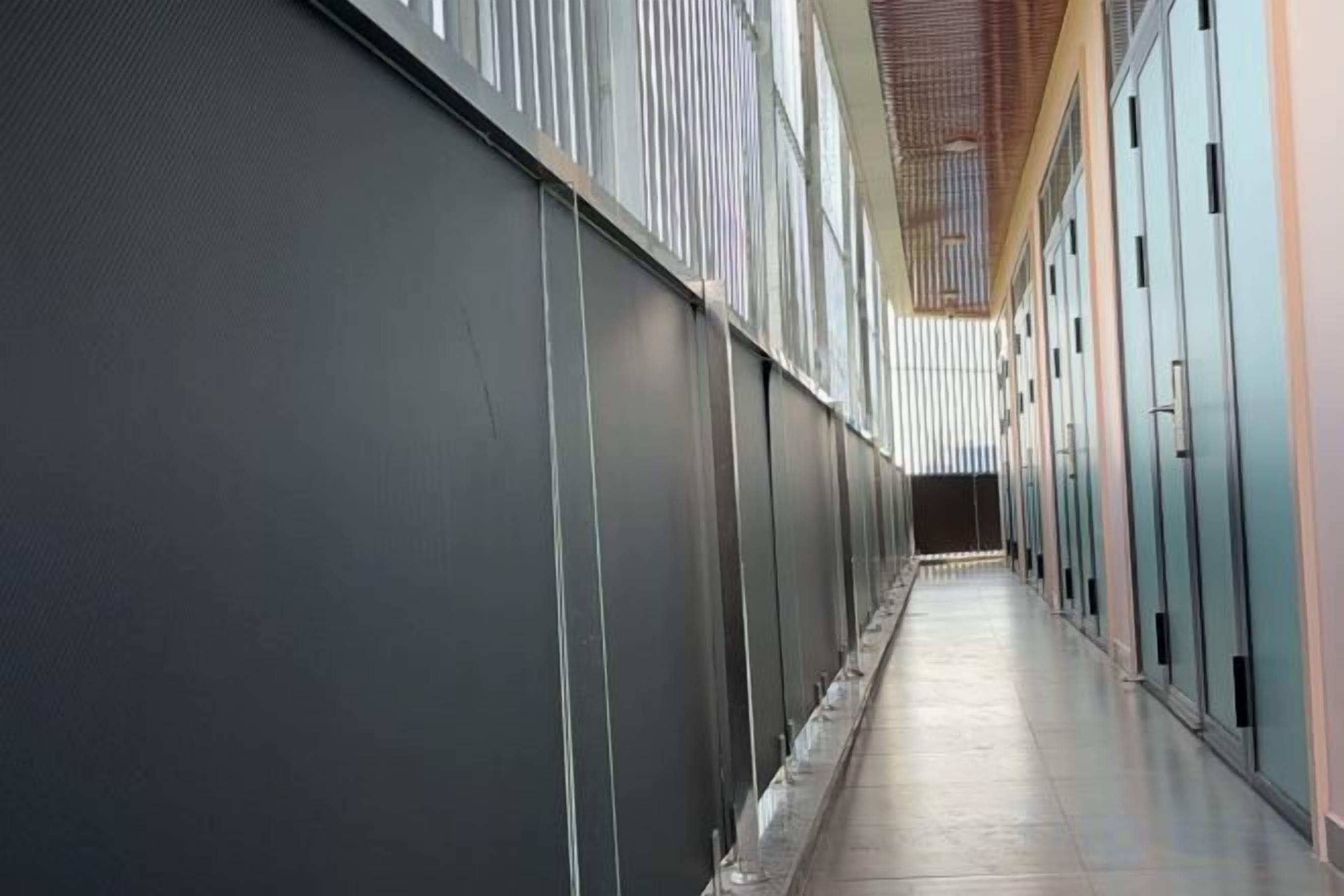 A corridor with lockers on one side and a wall on the other.