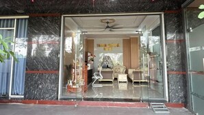 L’entrée d’un hôtel avec une porte en verre, un ventilateur de plafond et des décorations rouges suspendues.
