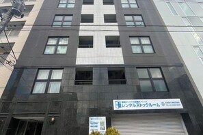 A multi-story building with a sign indicating a business or service center. - Arche de Reve (Tokyo)
