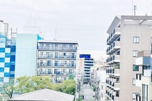 Un immeuble urbain moderne, doté de plusieurs étages, de balcons et d’une cour intérieure.
