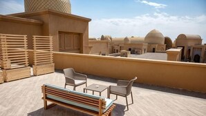 A rooftop terrace with a wooden bench, two chairs, and a table. - KARAVANSARAY Turkistan Family Hotel - Free FLYING THEATRE Entrance (Turkistan)
