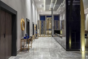 A hotel lobby with a marble floor, a reception desk, and a view of the lobby area.