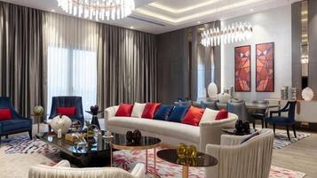 A modern living room with a sofa, armchairs, a coffee table, and a dining area.