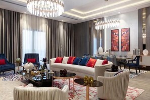 A modern living room with a sofa, armchairs, a coffee table, and a dining area. - KARAVANSARAY Turkistan Family Hotel - Free FLYING THEATRE Entrance (Turkistan)