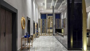 A modern hotel lobby with marble flooring, a reception desk, and a decorative wall. - KARAVANSARAY Turkistan Family Hotel - Free FLYING THEATRE Entrance (Turkistan)