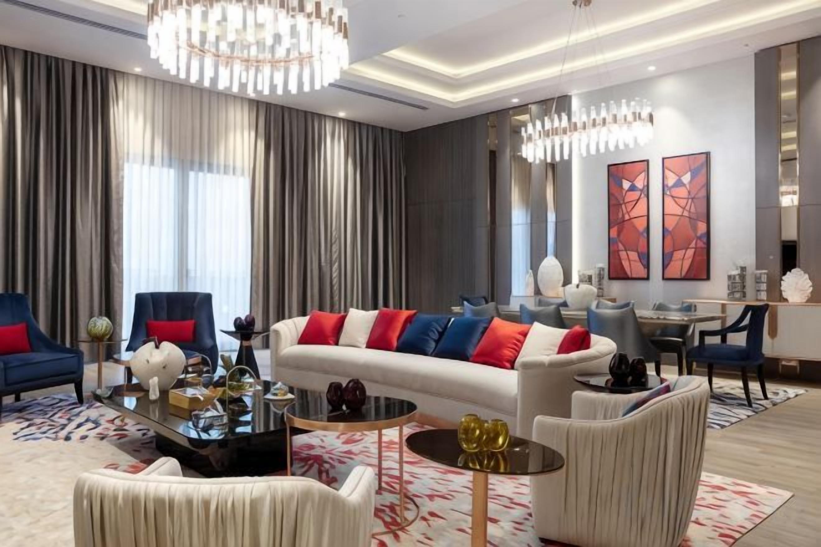 A modern living room with a sofa, armchairs, a coffee table, and a dining area.