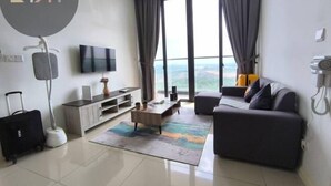 A modern living room with a sofa, a coffee table, a TV, and a view of the outdoors. - D'Pristine Homestay ByStay (Iskandar Puteri)