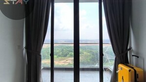 A room with a large window, curtains, and a suitcase. - D'Pristine Homestay ByStay (Iskandar Puteri)