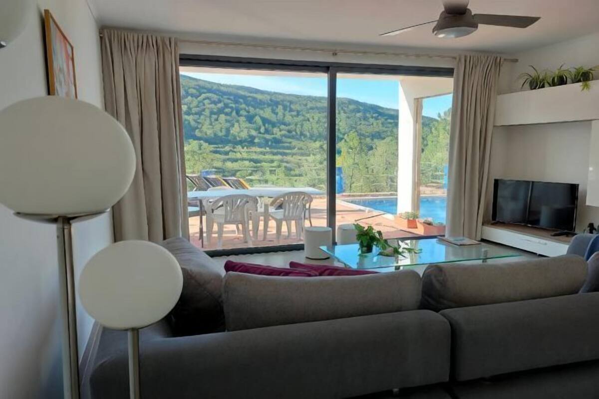 A living room with a sofa, TV, and a glass table.
