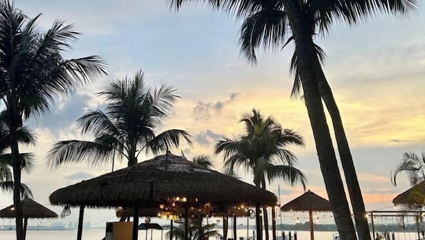 A beachside restaurant with thatched umbrellas, seating areas, and a view of the water. - Astonishing Ocean View 4 Bedrooms Huge Balcony 2 Car Park (Johor Bahru)
