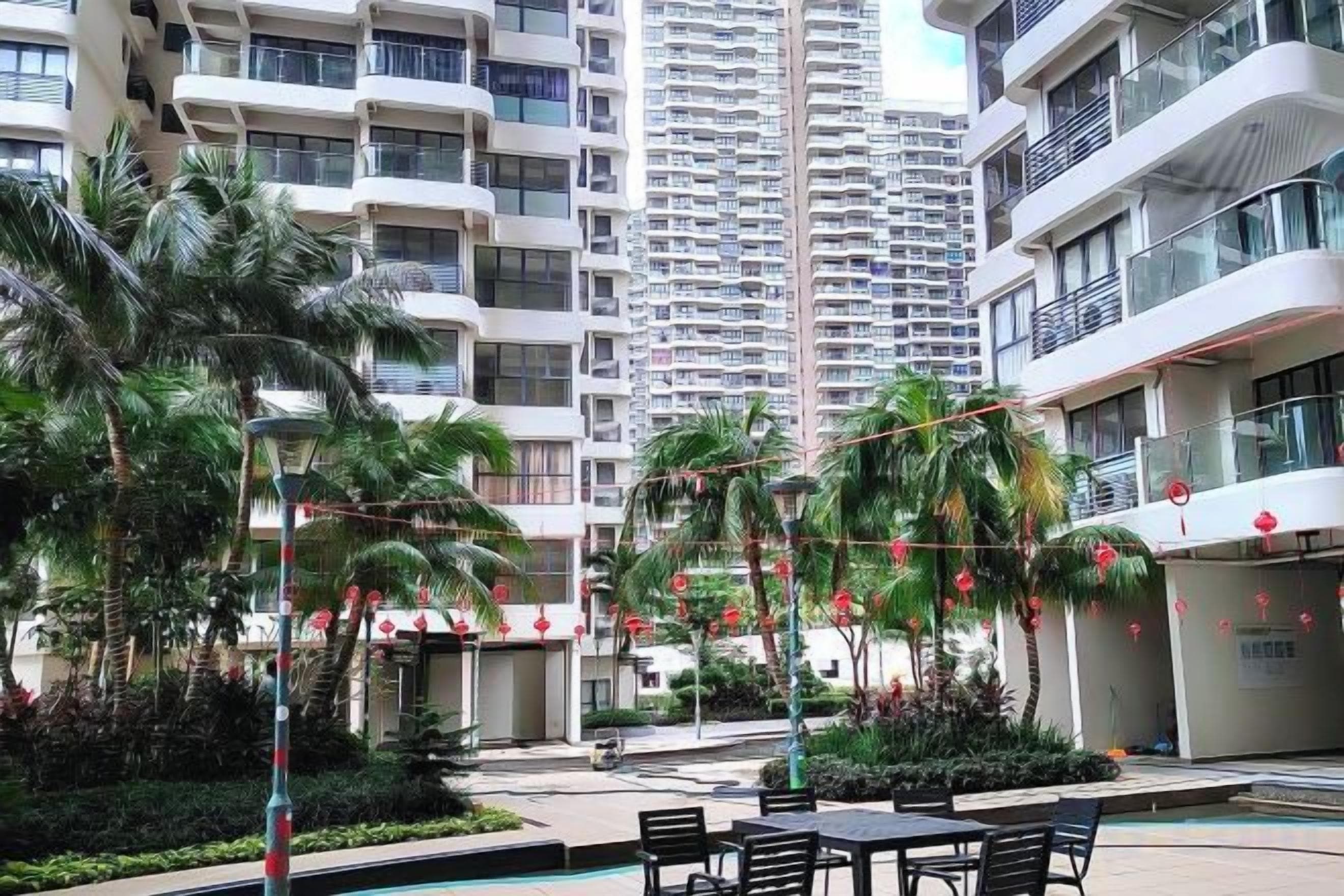 A residential building with balconies, a swimming pool, and outdoor seating.
