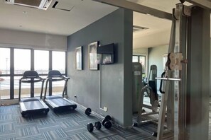 Una palestra con tapis roulant, pesi e attrezzature per esercizi.