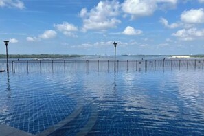 Une piscine avec vue sur la mer et les bâtiments situ és au loin.