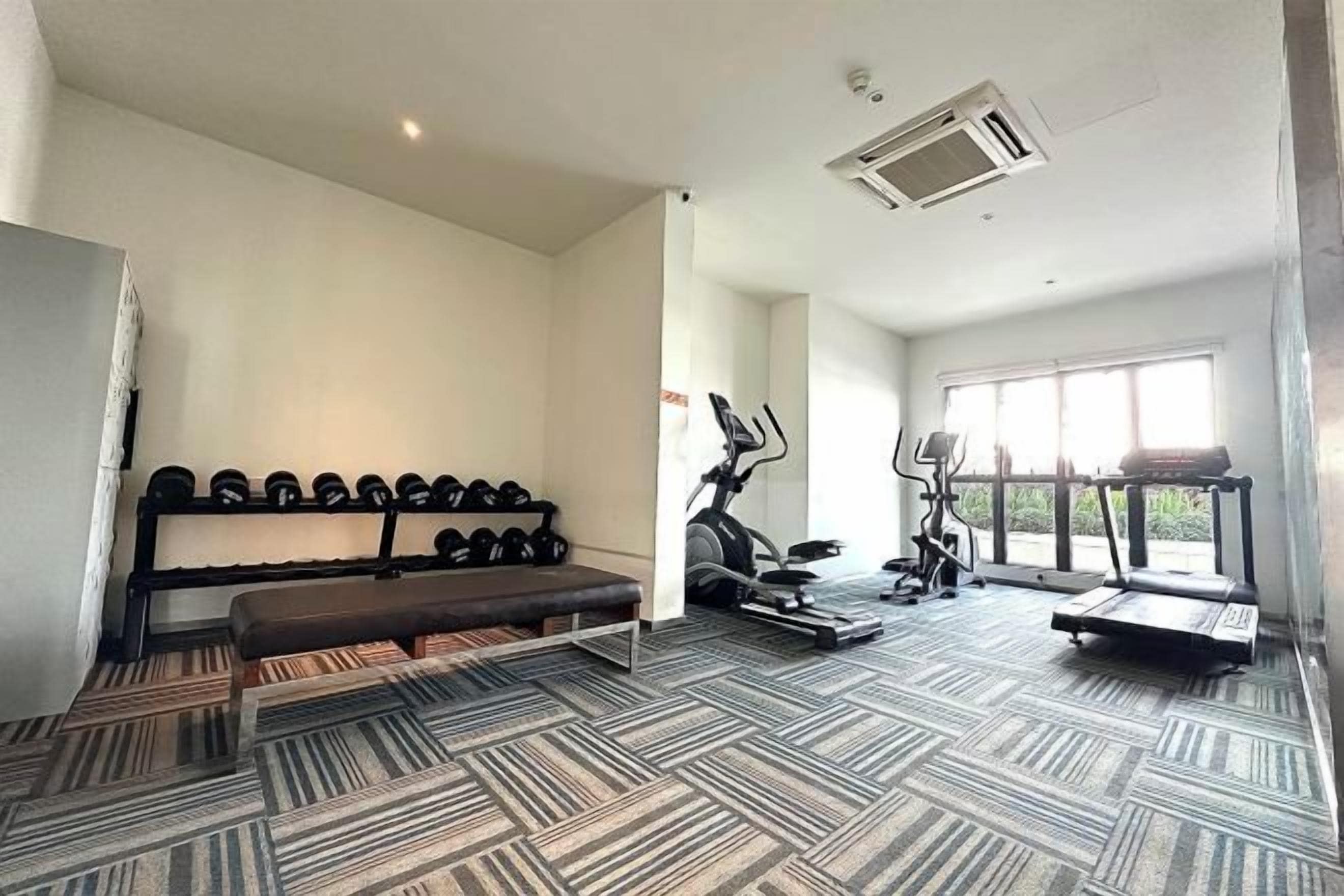 A gym with exercise equipment, a bench, and a shoe rack.