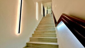 A staircase with wooden steps and a handrail, illuminated by vertical light strips on the walls. - Hota Inn Limbang (Limbang)