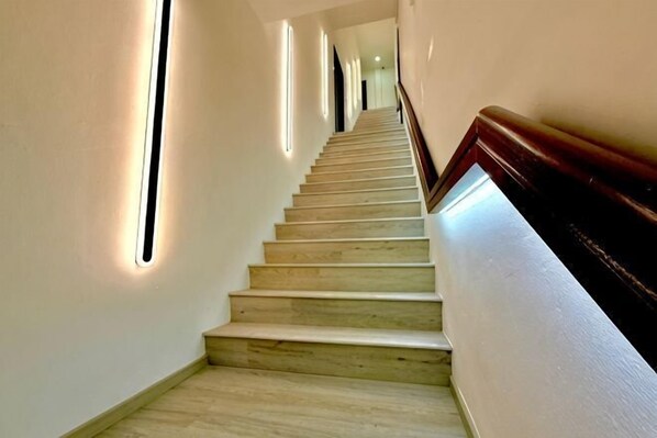 A staircase with wooden steps and a handrail, illuminated by vertical light strips on the walls. - Hota Inn Limbang (Limbang)