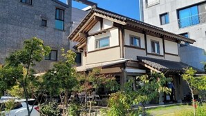 A two-story building with a traditional architectural style, featuring a tiled roof and wooden beams. - Incheon Airport ANN Guesthouse (Incheon)