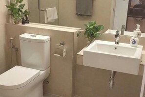 Ein Badezimmer mit Toilette, Waschbecken und Spiegel.
