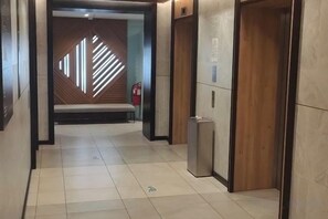 A hallway with a bench, a fire extinguisher, and an elevator. - Windmills Upon Hills Hotels & Residences Genting Highland (Genting Highlands)