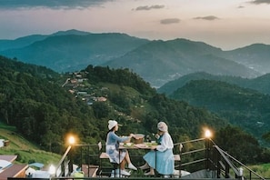 A couple dining at a table with a scenic mountain view.