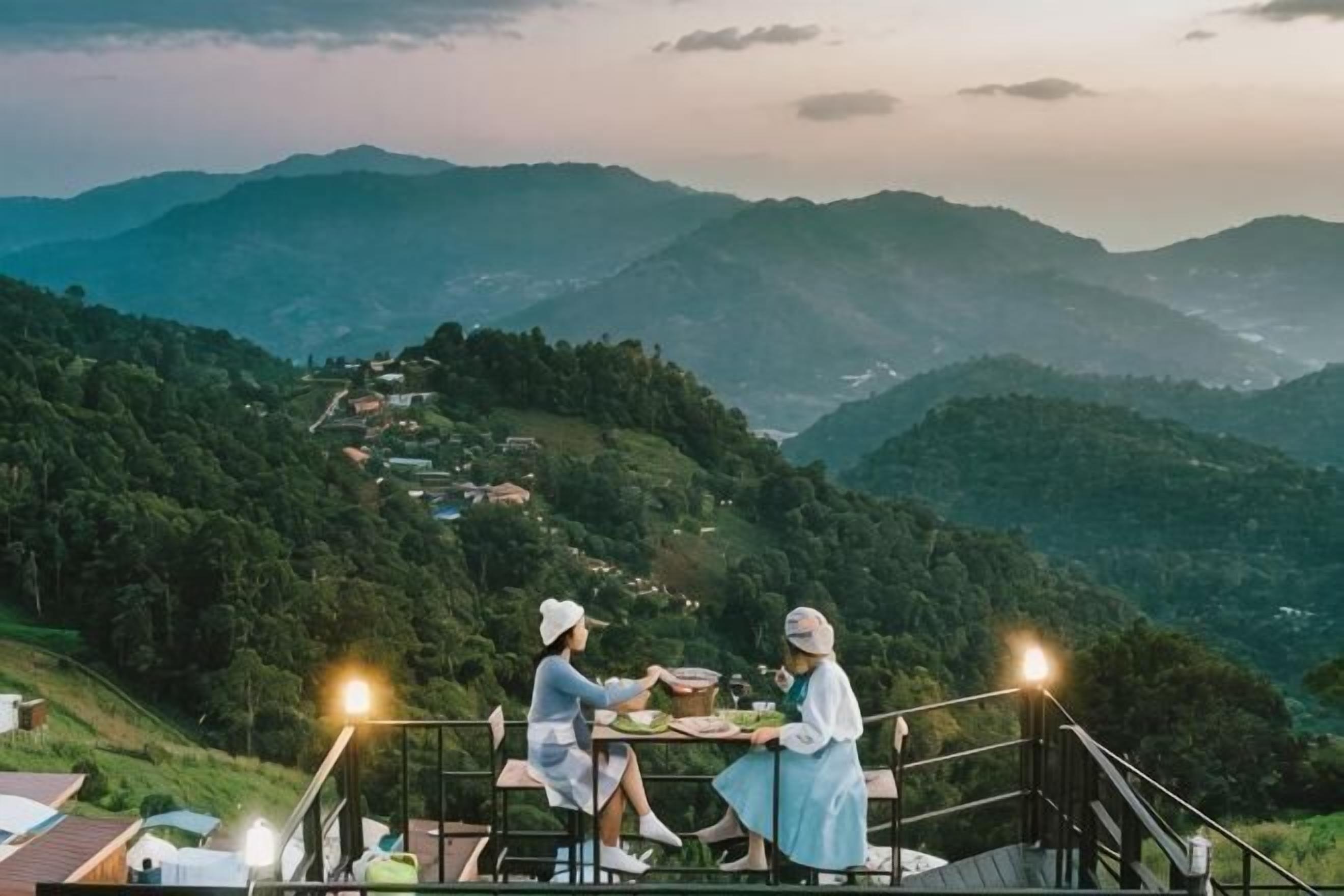 Una pareja cenando en una mesa con vistas panorámicas a la montaña.