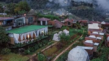 Un pueblo rural con varias casas de madera, una estructura tipo tienda de campaña y un edificio con forma de cúpula.