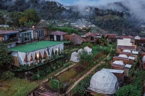 Un pueblo rural con varias casas de madera, una estructura tipo tienda de campaña y un edificio con forma de cúpula.