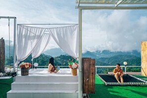 A rooftop terrace with a white canopy, a pool, and a scenic mountain view. - Phutawan monjam (Mae Rim)