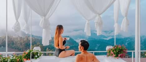 Una pareja sentada en un banco con vista a las montañas.