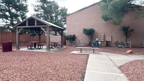 A covered picnic area with benches, a trash can, and bicycles parked against a building. - Pool, 5G HSI w/Coffee, Trails, and Golf Nearby (Sedona)