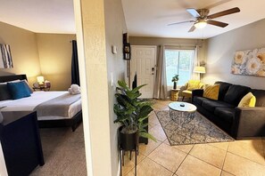 A hotel room with a bed, a sofa, a coffee table, a potted plant, and a ceiling fan. - Pool, 5G HSI w/Coffee, Trails, and Golf Nearby (Sedona)