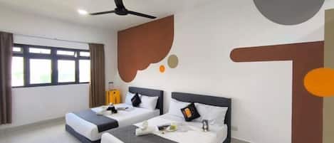 A hotel room with two beds, a ceiling fan, and a large wall mural.