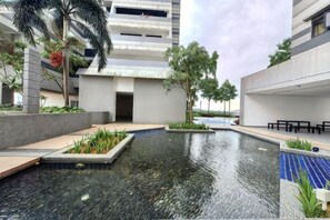 Ein modernes Gebäude mit Poolbereich, Außenbereich zum Sitzen und blauem Himmel.