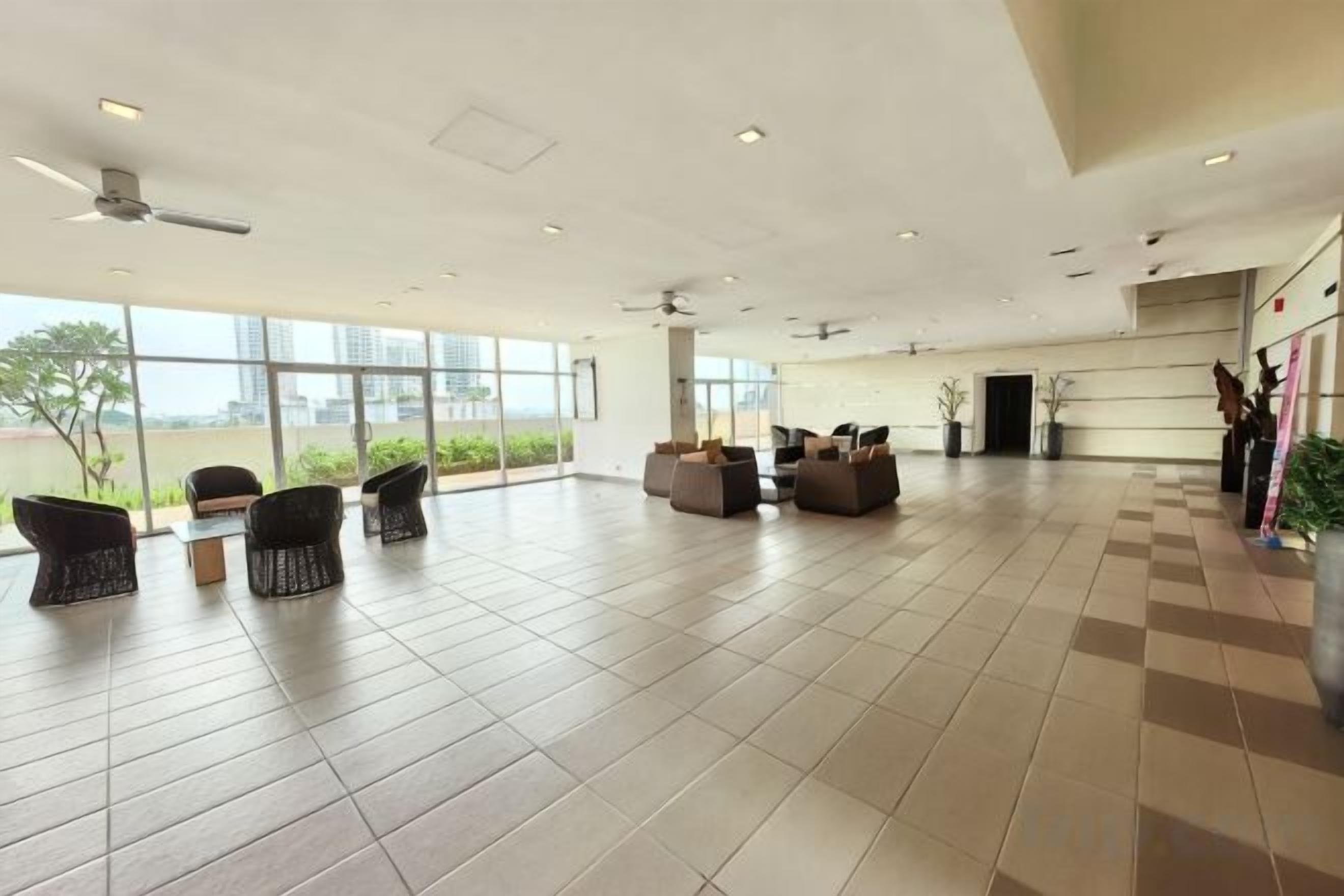 Un vestíbulo amplio con asientos, ventanas grandes y vistas al exterior.