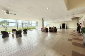 Un vestíbulo amplio con asientos, ventanas grandes y vistas al exterior.