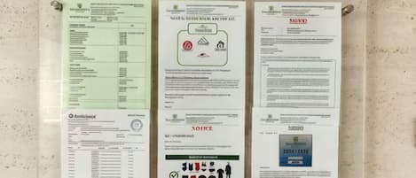 A bulletin board with various notices and informational posters, including safety guidelines and emergency procedures.