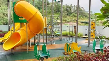 A playground with a yellow slide and climbing structures.