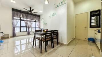 A dining area with a table and chairs, a ceiling fan, and a window with curtains.