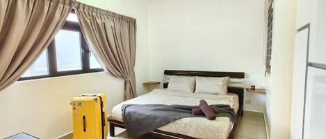 Un dormitorio con cama, cortinas, maleta, ventilador de techo y ventana.